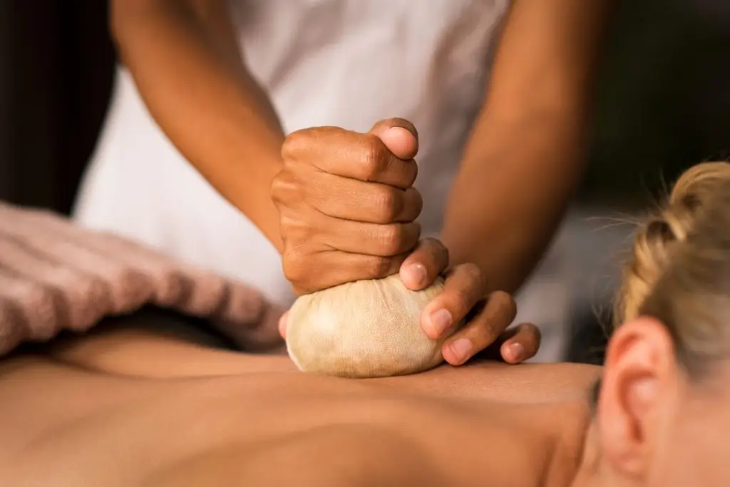 Thai herbal massage in Bangkok spa – warm compress with essential oils for deep healing